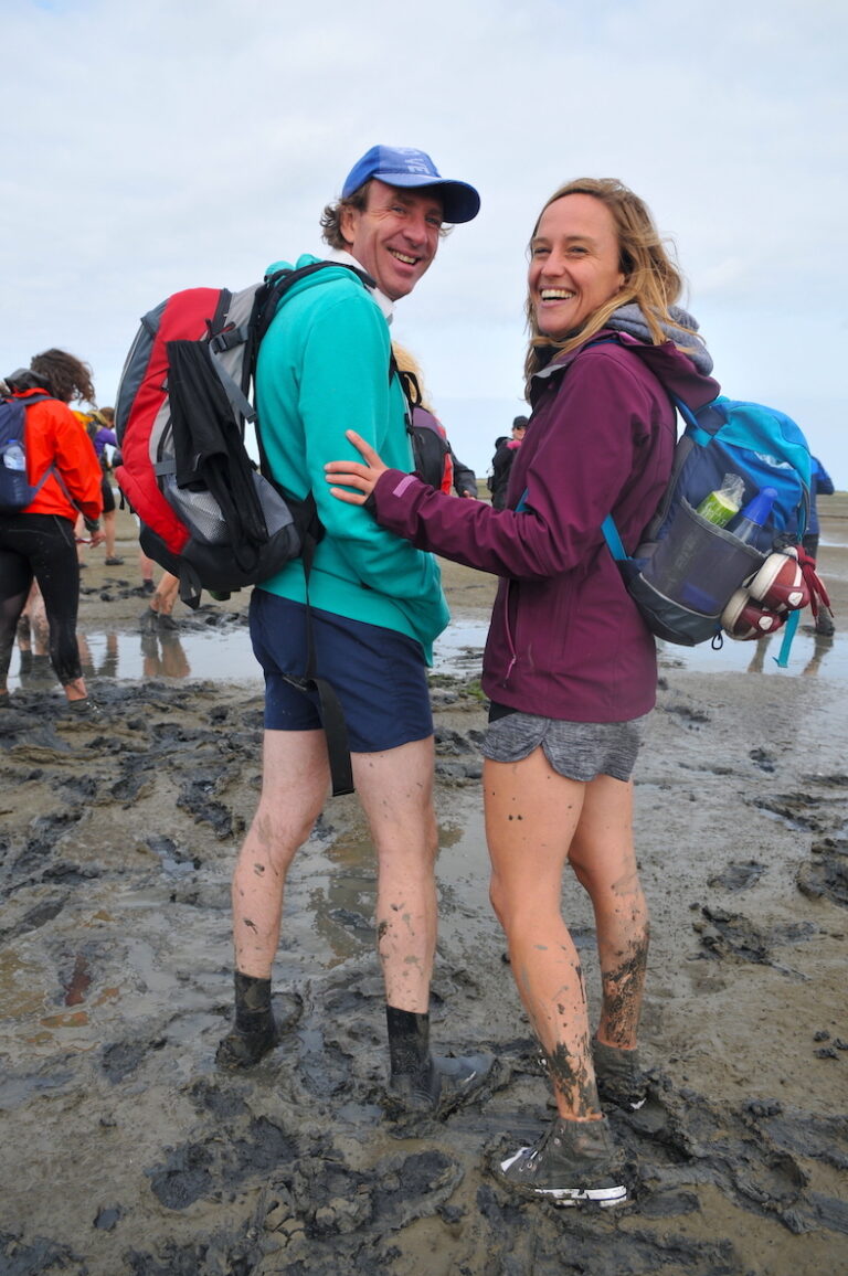 Two people in mud of Wadden Zee